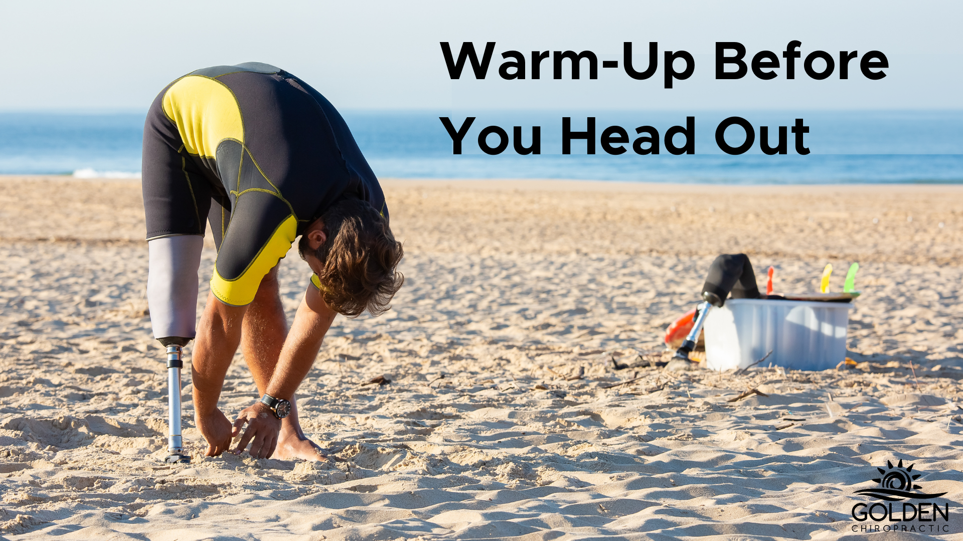 Man with a prosthetic leg in wetsuit stretching in a forward fold on the beach