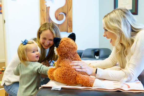 Dr. michaela engaging with a mother and her toddler