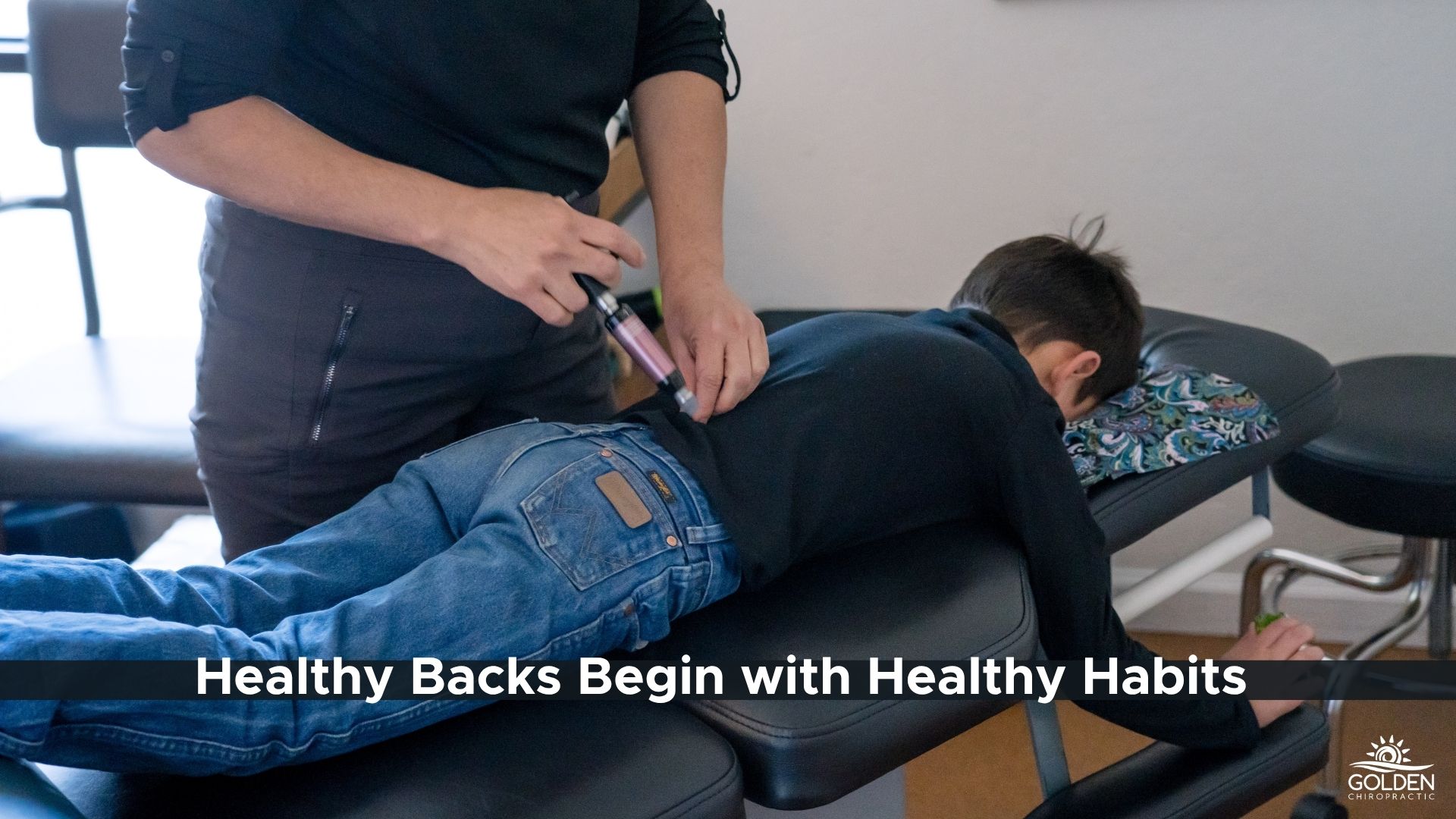 Dr. Goldi of Golden Chiropractic in Aptos uses an activator on a school age boy to help with backpack and school related pain