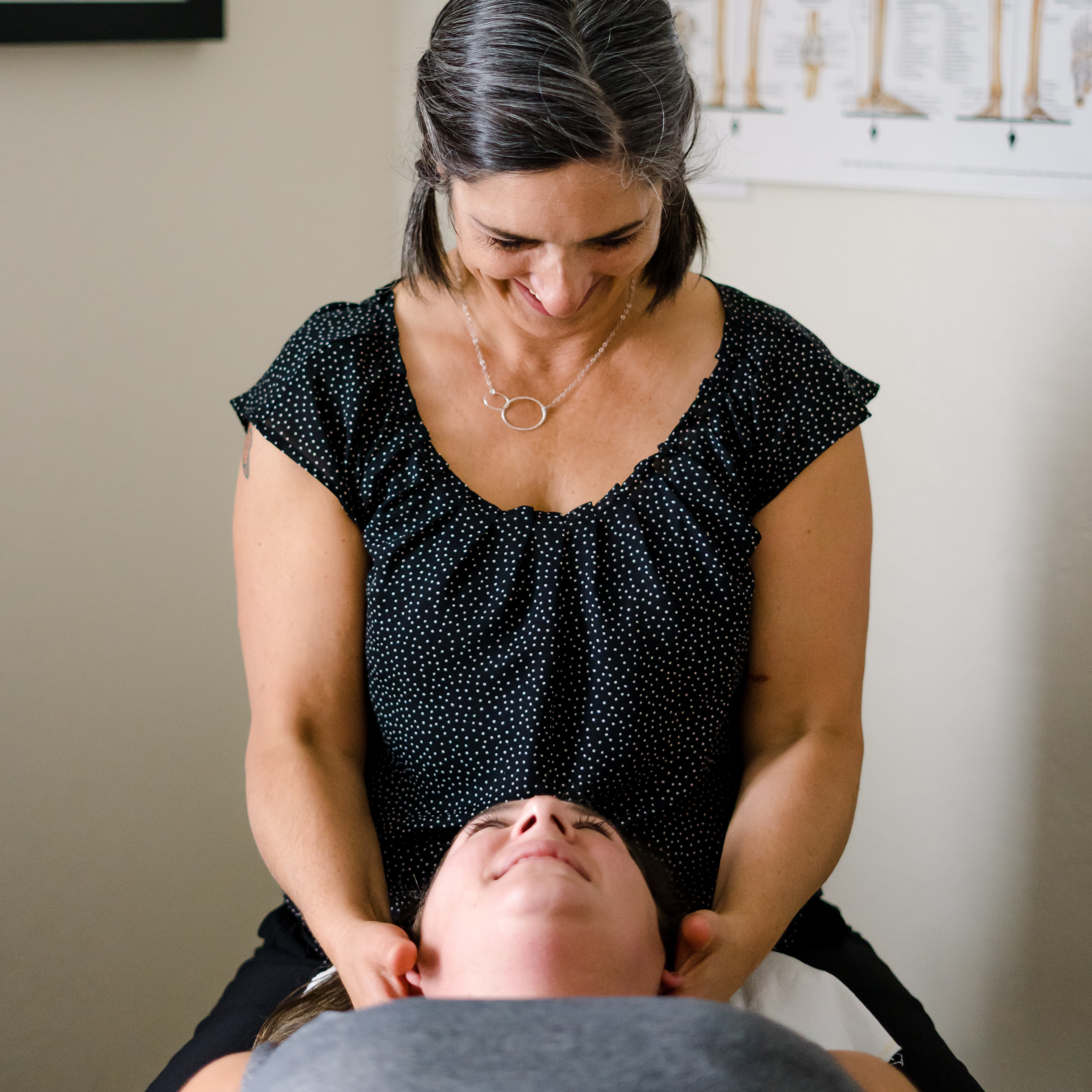 dr Goldi cradles a patients face while the patient looks up at her from the table