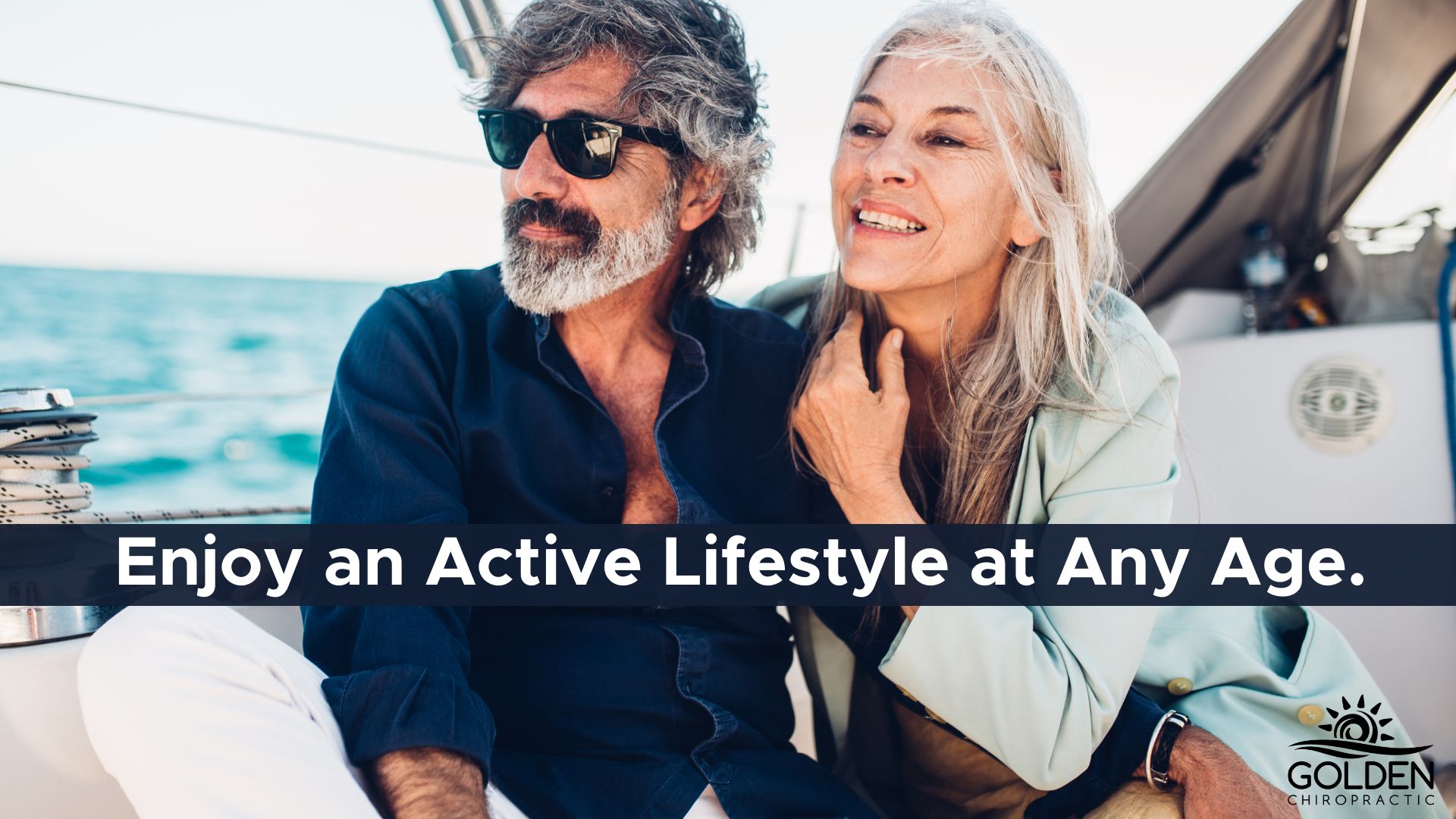 older woman and older man smiling on a sail boat in the ocean