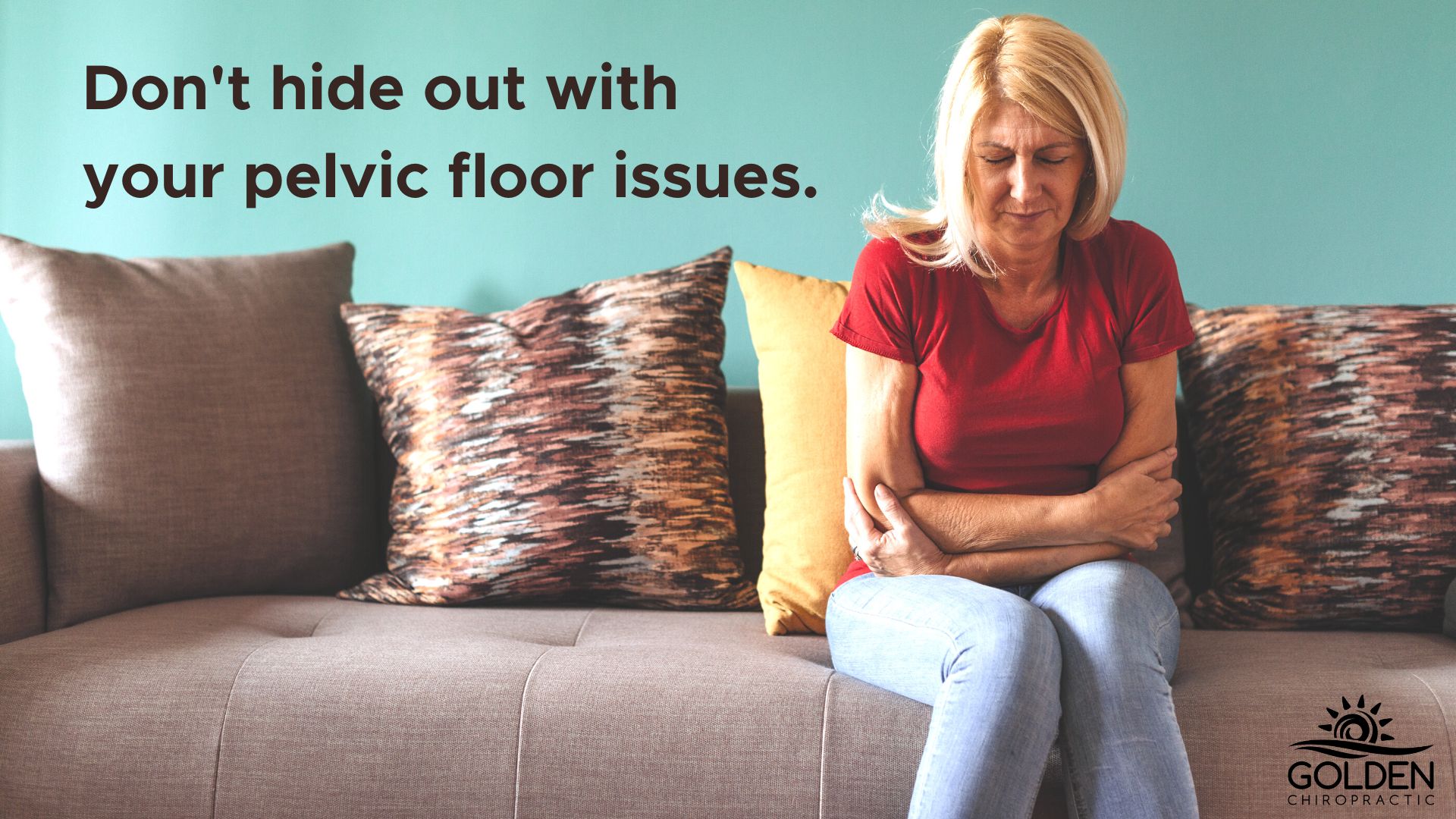 woman sitting on a sofa looking down and crossing her arms in her lap looking distressed