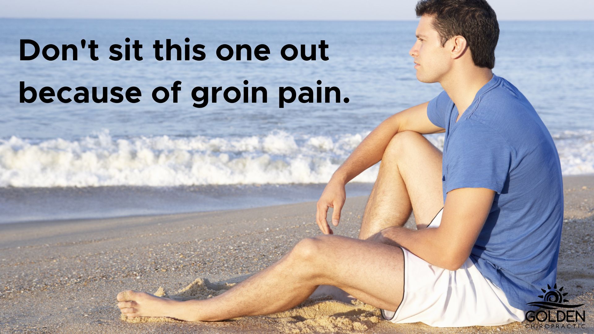 man sitting on beach looking at the ocean