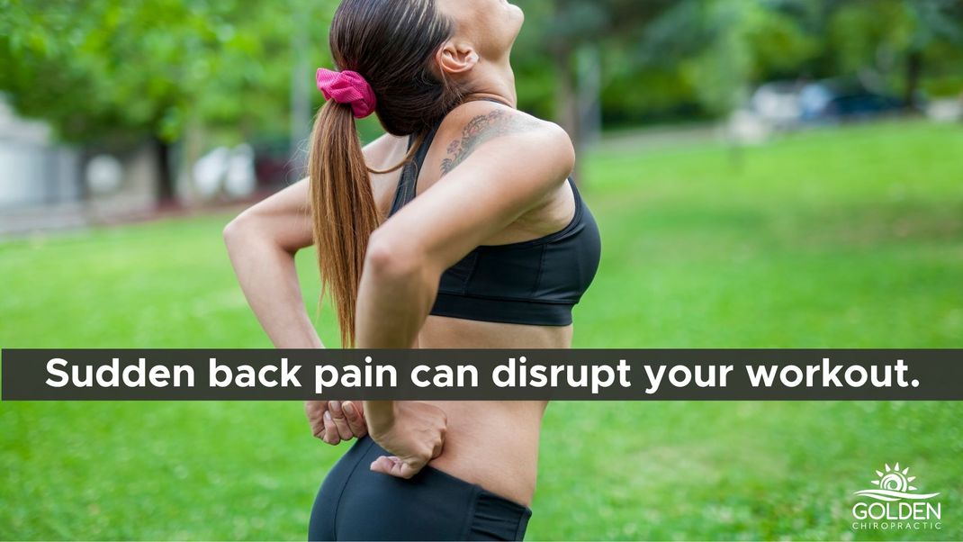 Woman in workout gear outdoors, clutching her lower back in pain