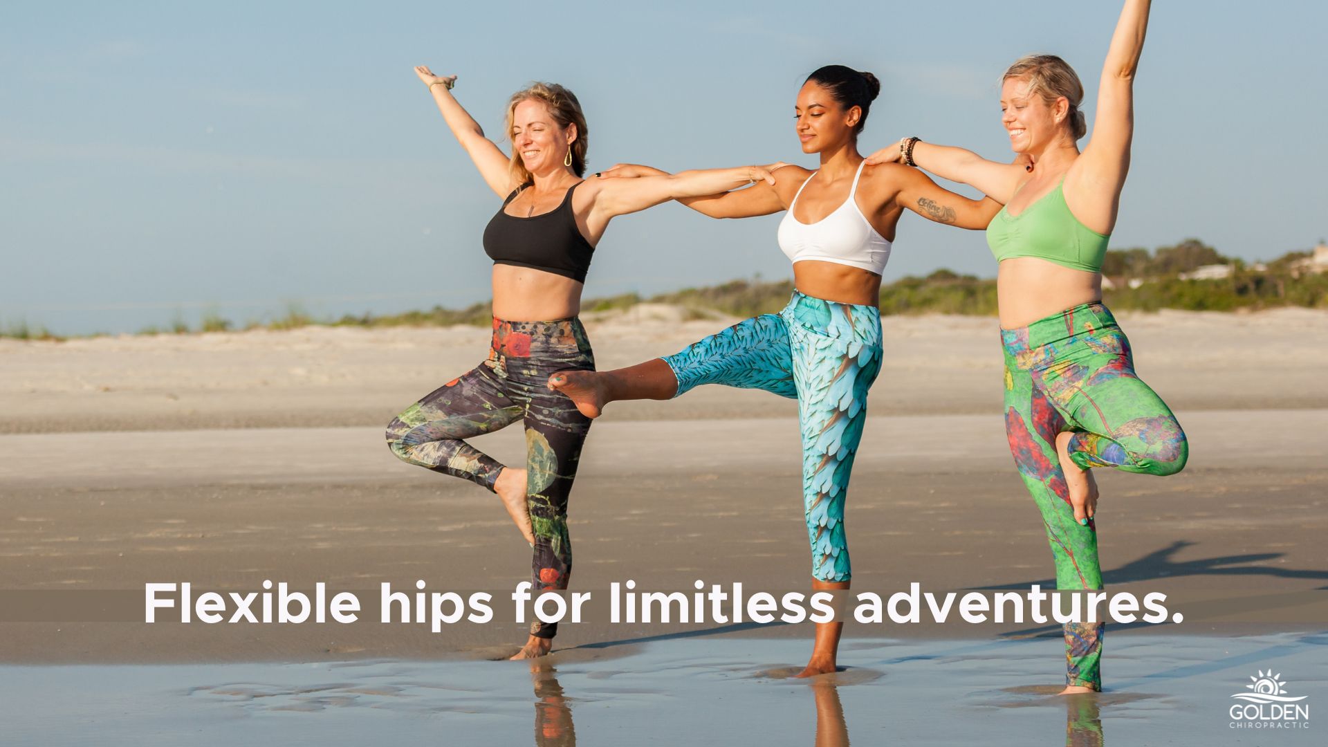 Three young women doing balancing poses on the beach