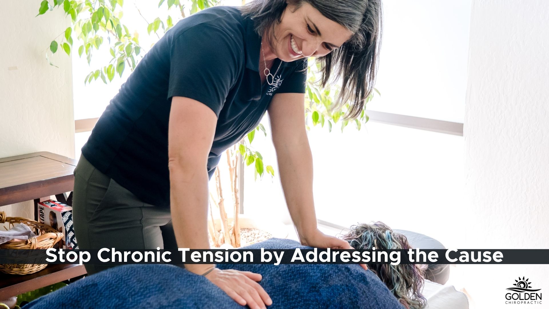 Dr Goldi of Golden Chiropractic in Aptos assesses the back of a female patient 