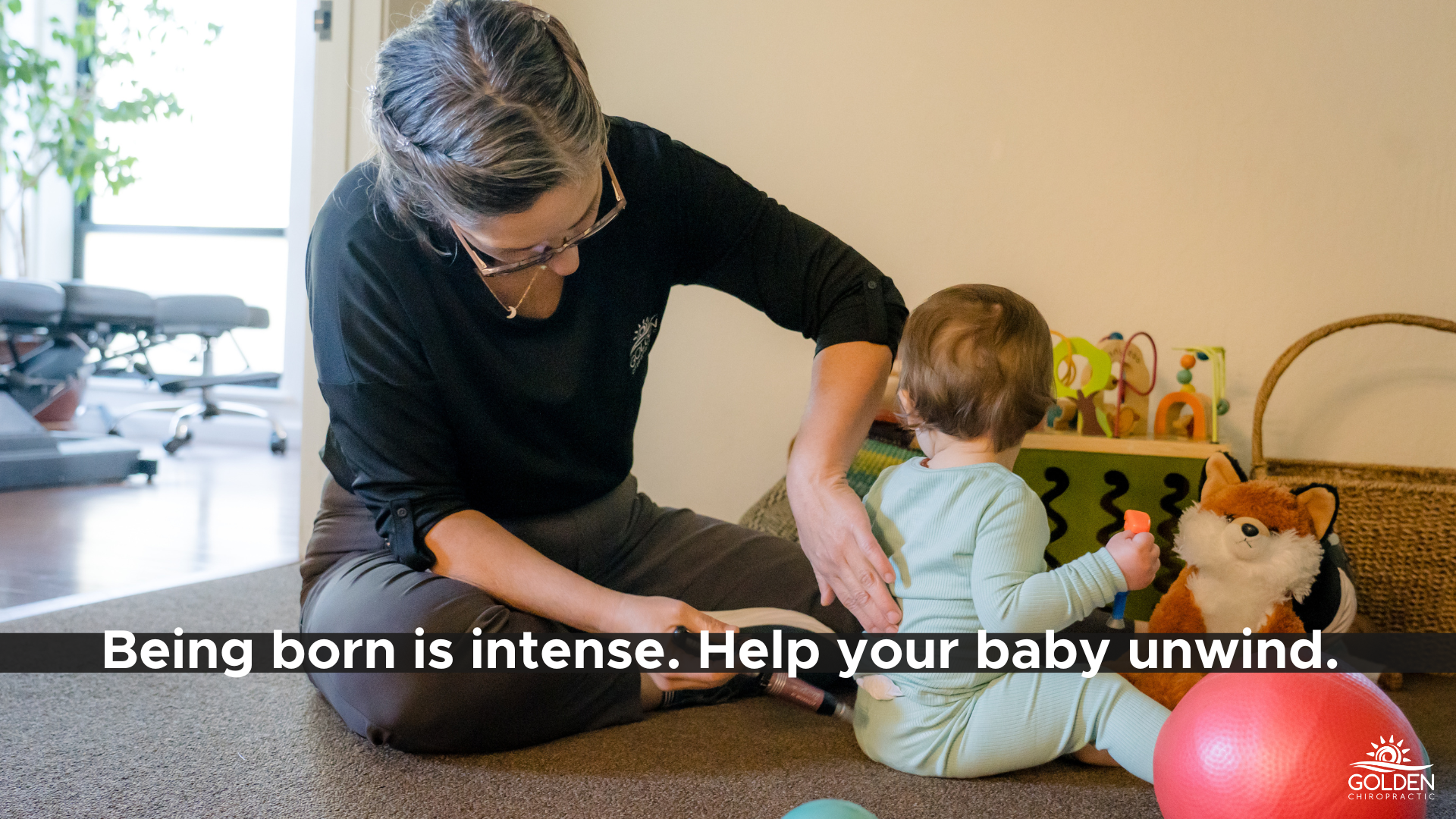 Dr. Goldi using an activator on a baby's low back at Golden Chiropractic in Aptos