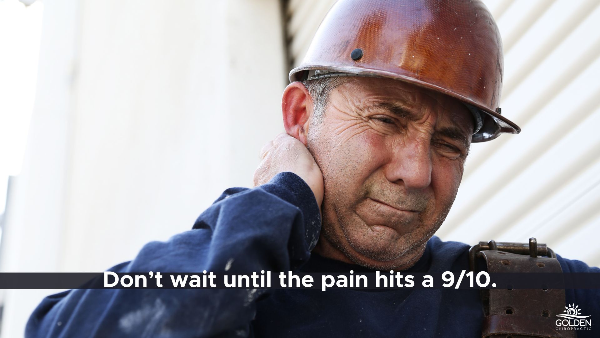 older construction worker clutching his neck in pain